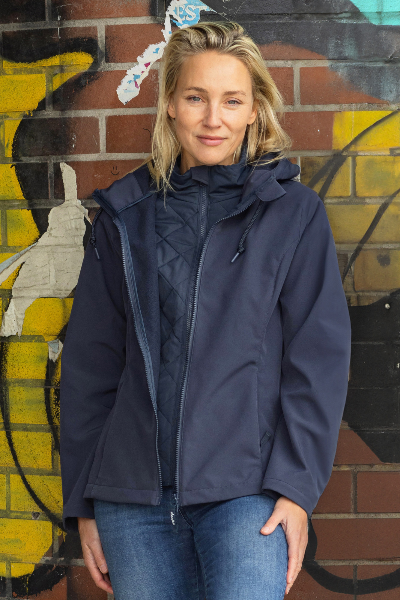 Model trägt blauen Softshelljacke Stimmungsbild draussen