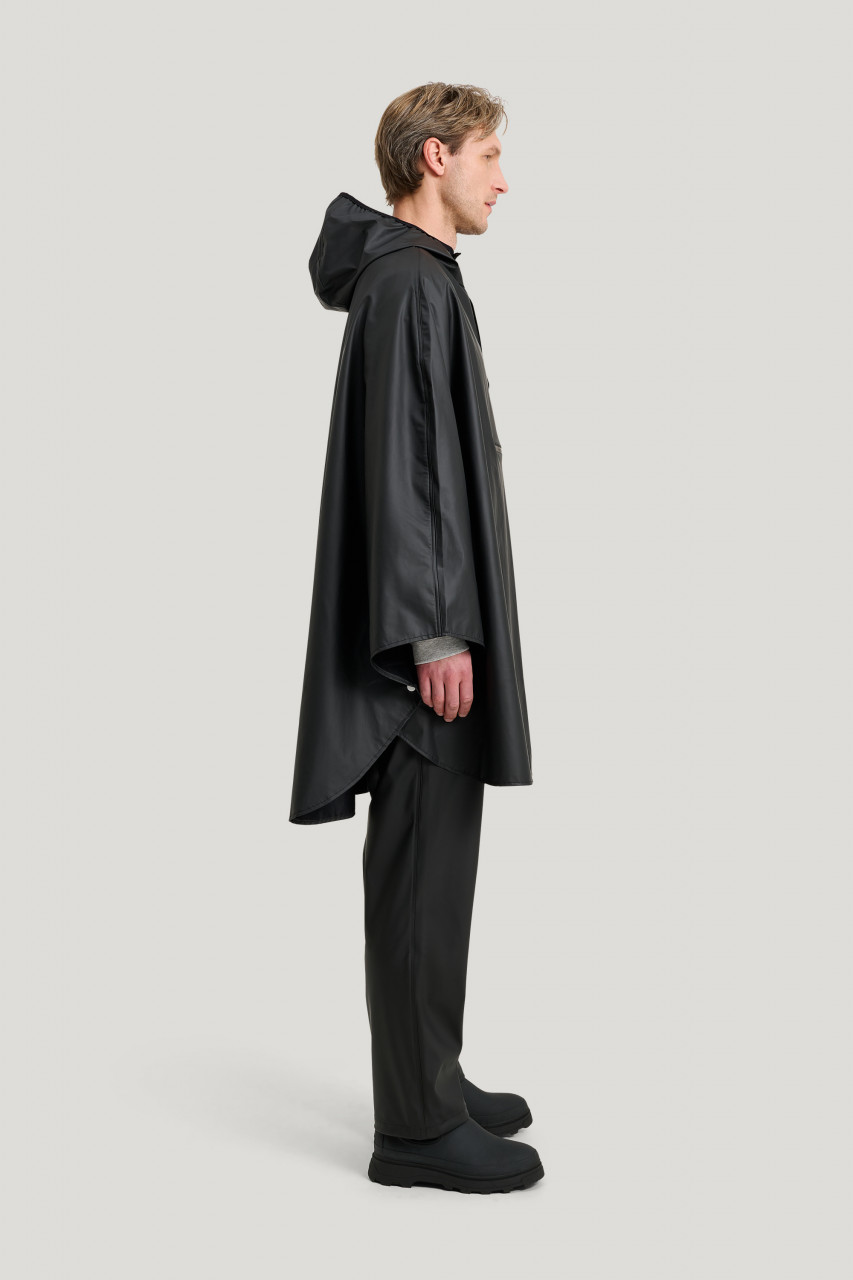 Model trägt ein Regenponcho schwarz von Tretorn - Seitenansicht