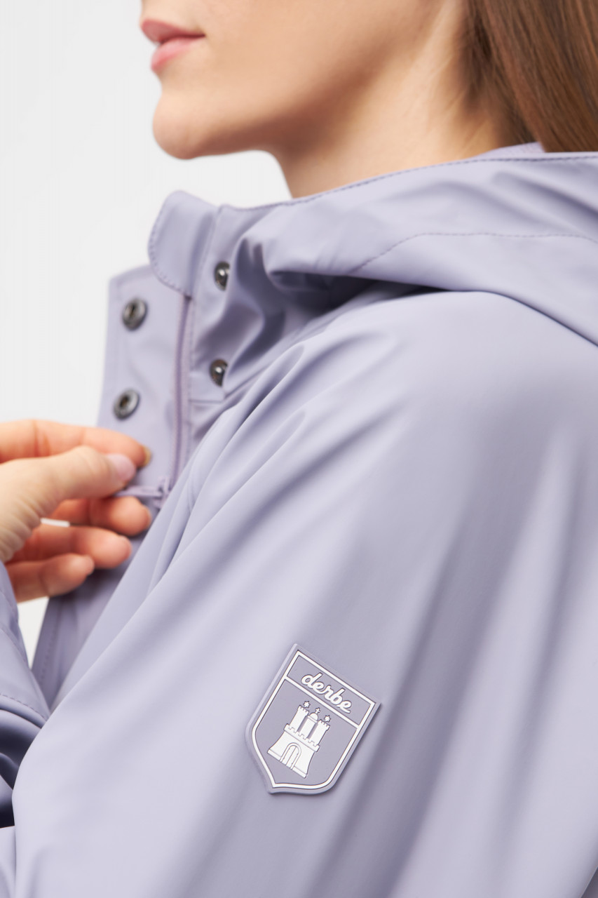 Model trägt eine violetten Regenjacke Damen von derbe - Seitlich