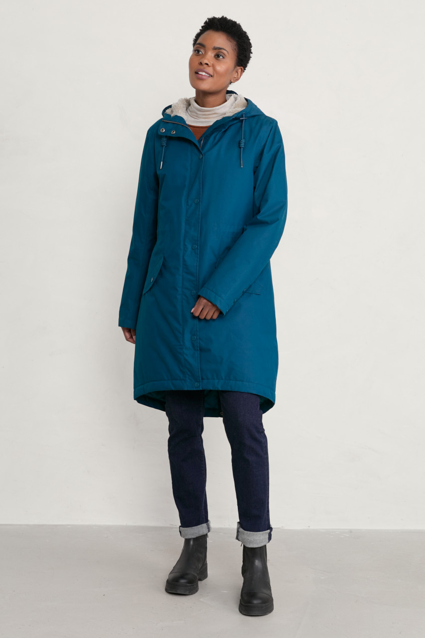 Model trägt türkisen Regenjacke