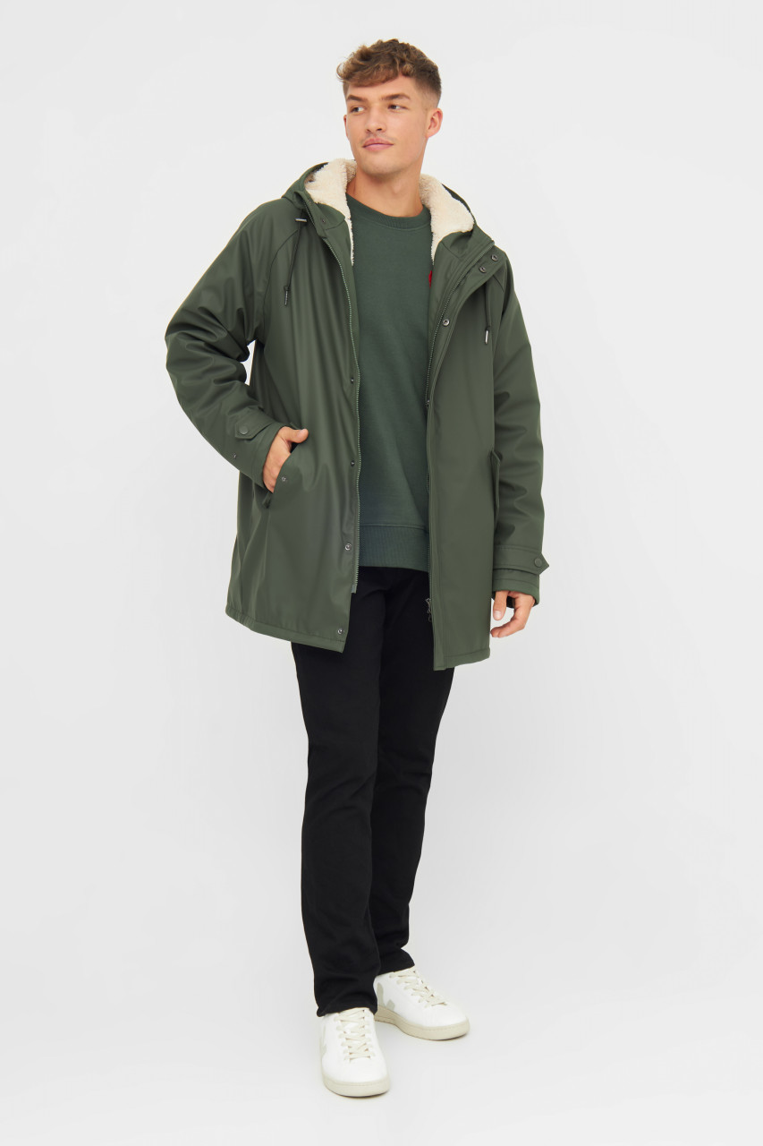Mann trägt eine Regenjacke grün von derbe