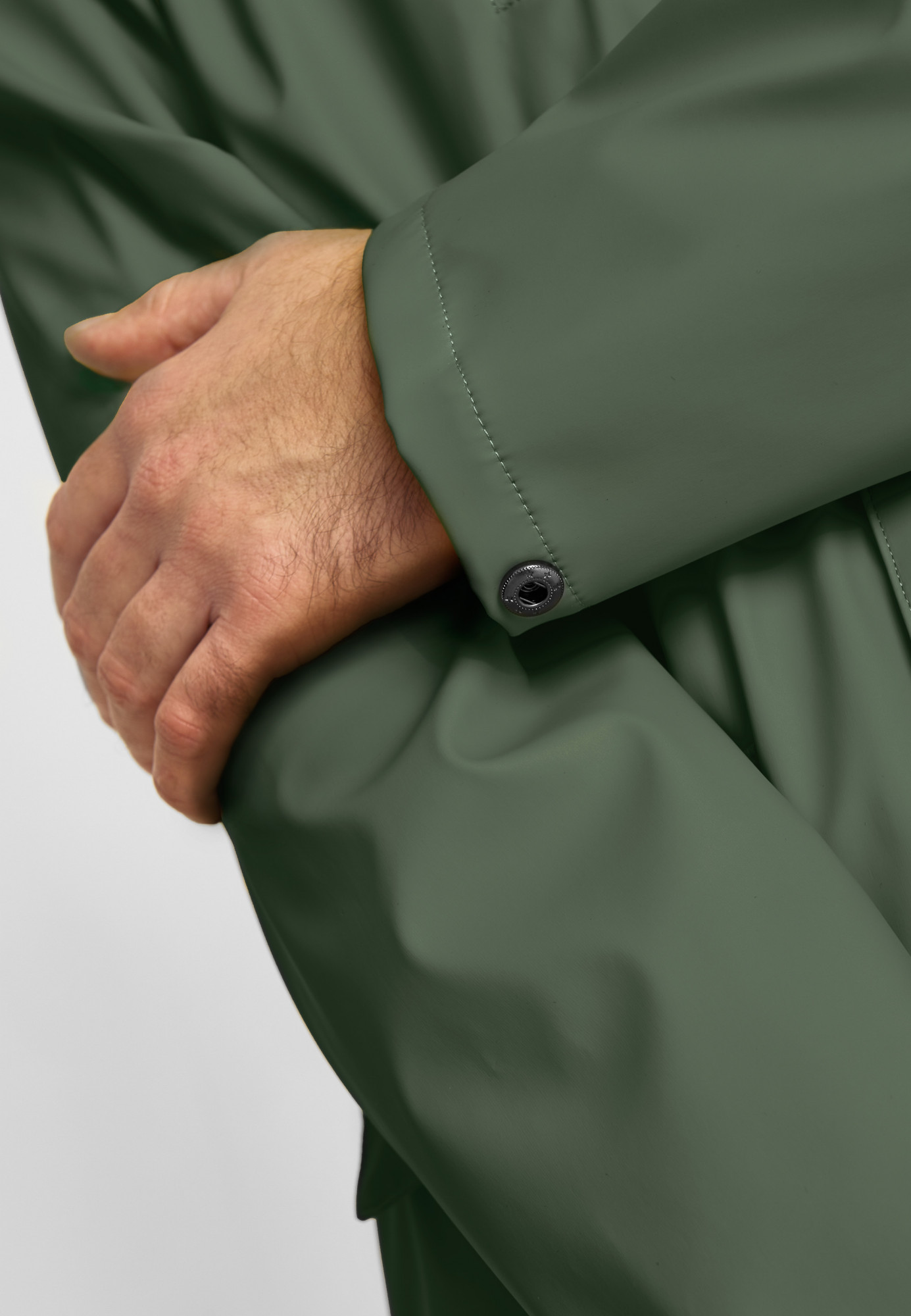 Model trägt eine oliv grünen Regenjacke Herren von derbe