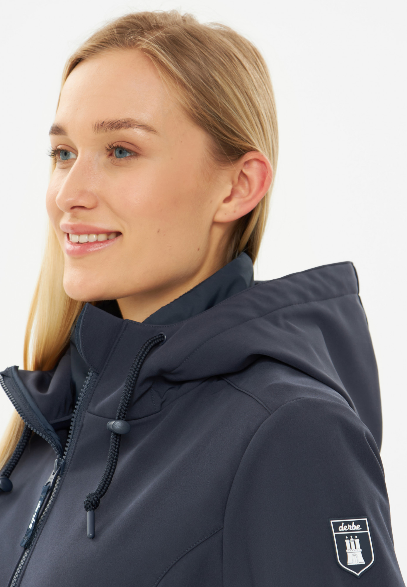 Frau trägt eine blauen Softshelljacke Damen von derbe - Seite