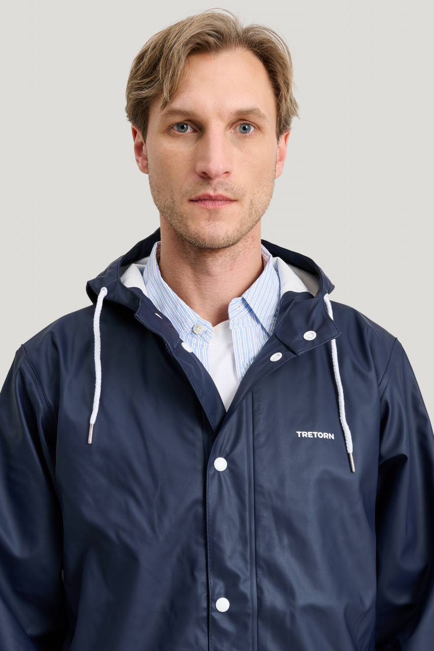 Mann trägt eine Regenjacke blau von Tretorn