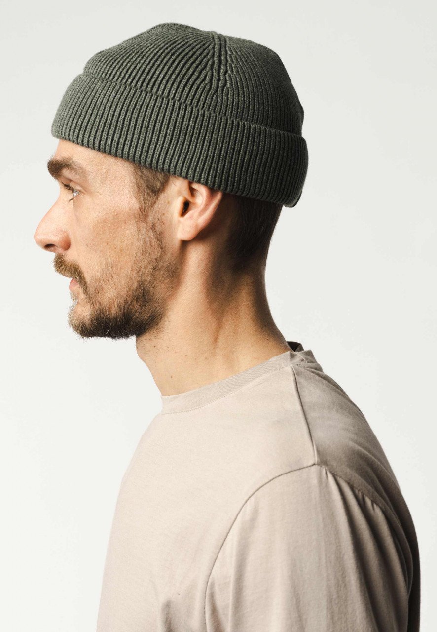 Model trägt eine grünen Strickmütze Unisex von MELA  - Seitenansicht