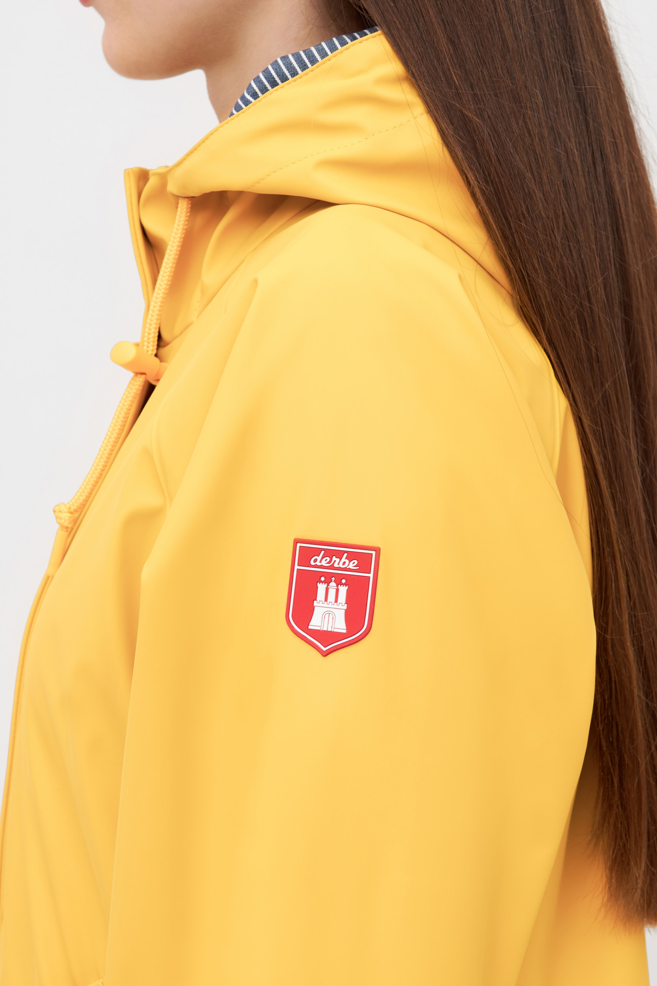 Weibliches Model trägt eine Regenjacke gelb von derbe - Seitenansicht
