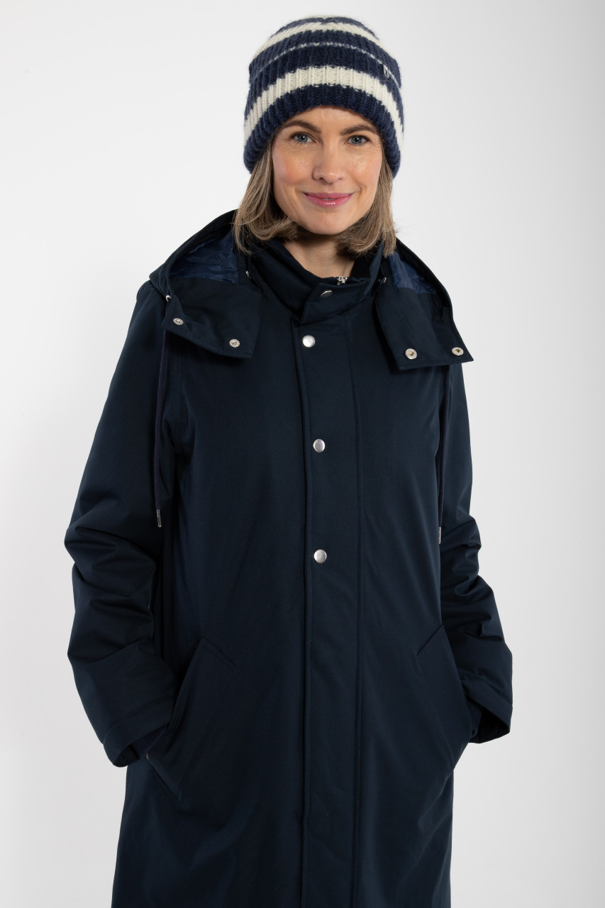 Weibliches Model trägt blauen Wintermantel