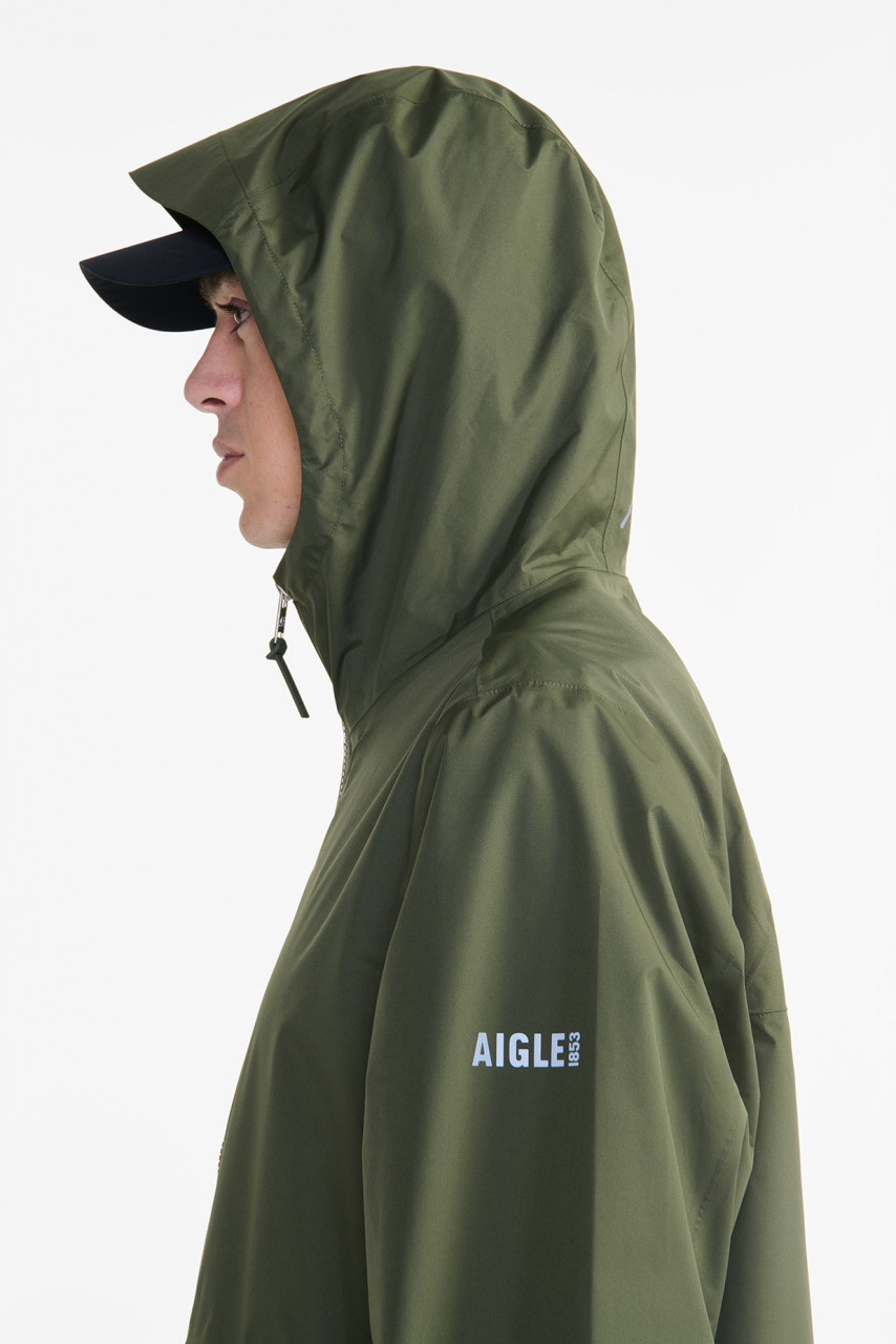 Model trägt oliv grüne Regenjacke - Seitenansicht
