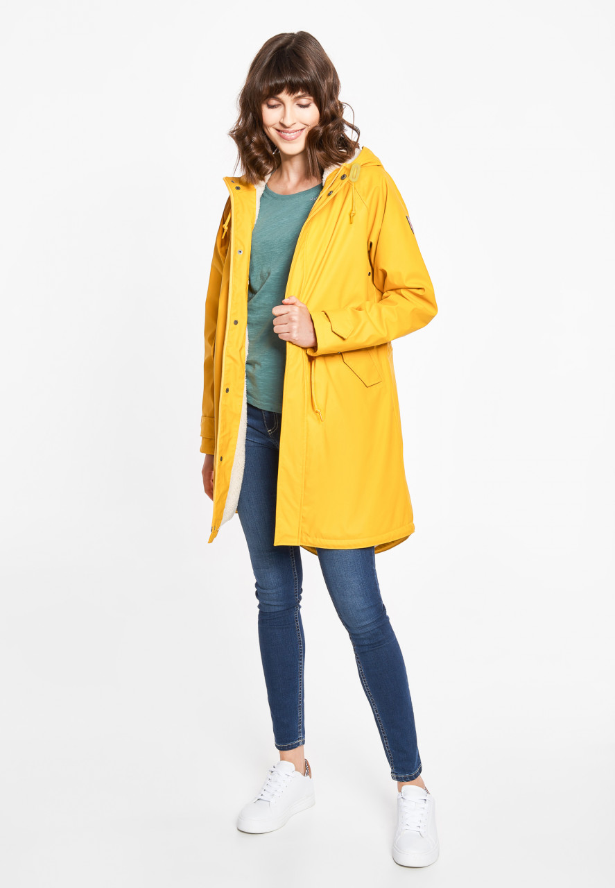 Model trägt eine Regenjacke gelb von derbe