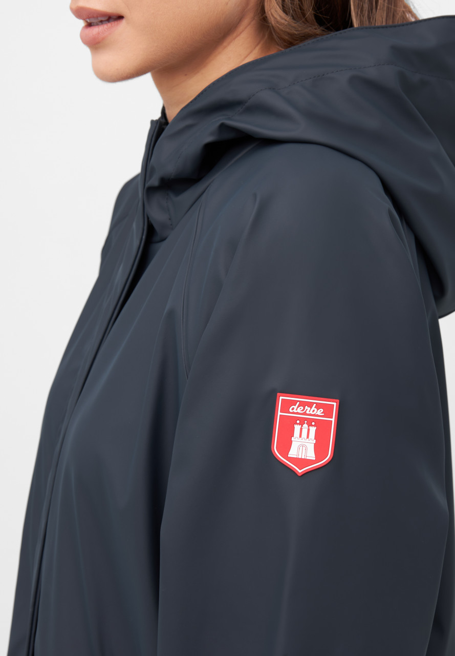 Frau trägt eine Regenjacke blau von derbe - Seitlich