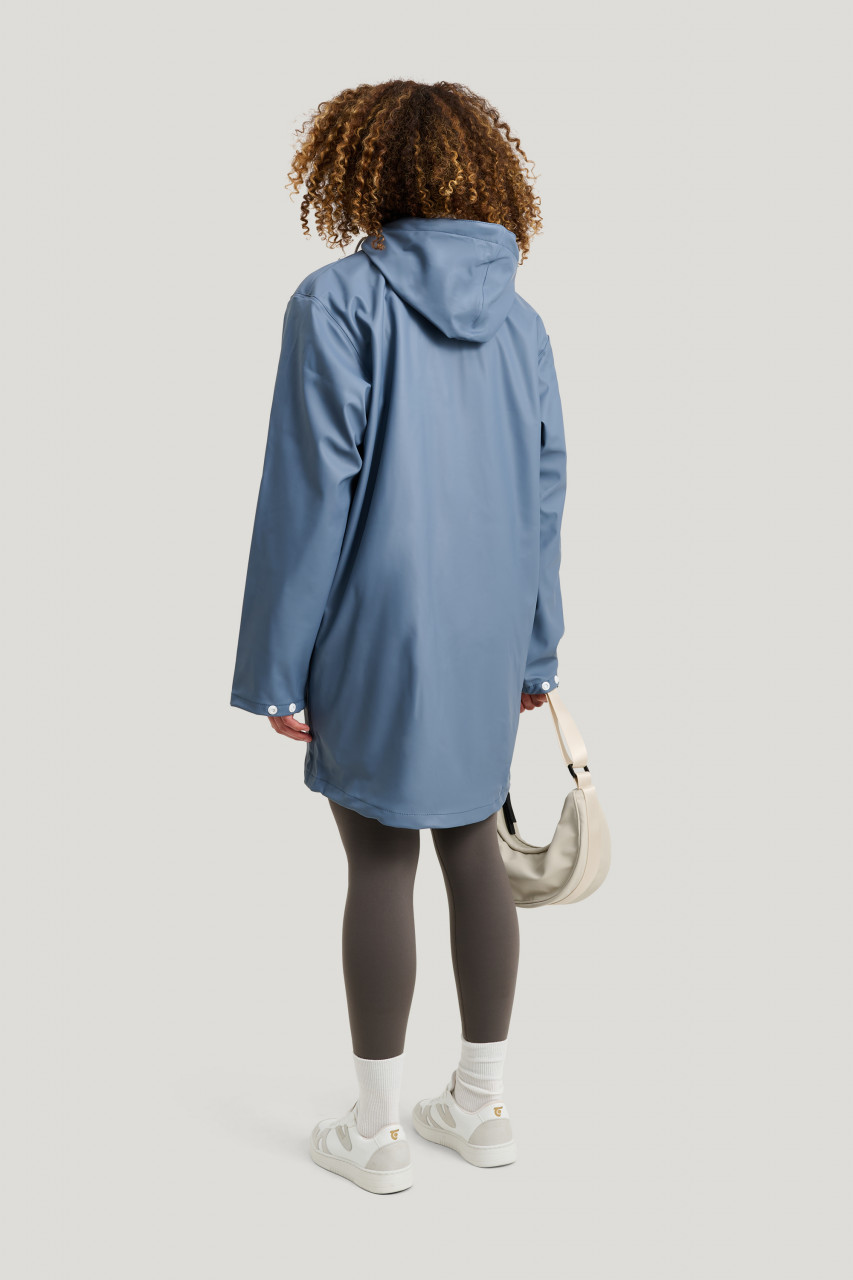 Frau trägt Regenjacke blau - Rückansicht