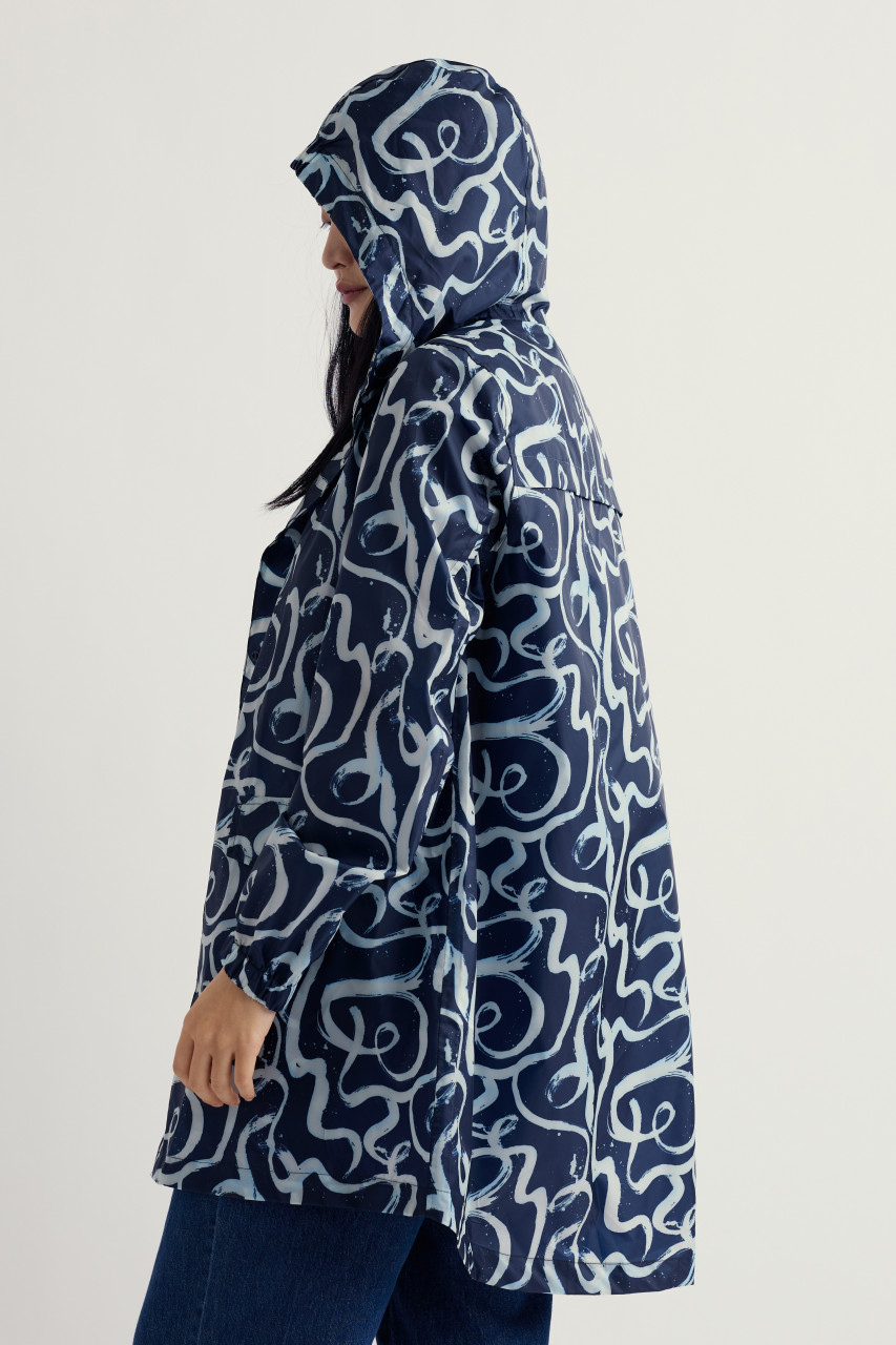 Weibliches Model trägt blau weiß wirbele Regenjacke - Rückseite