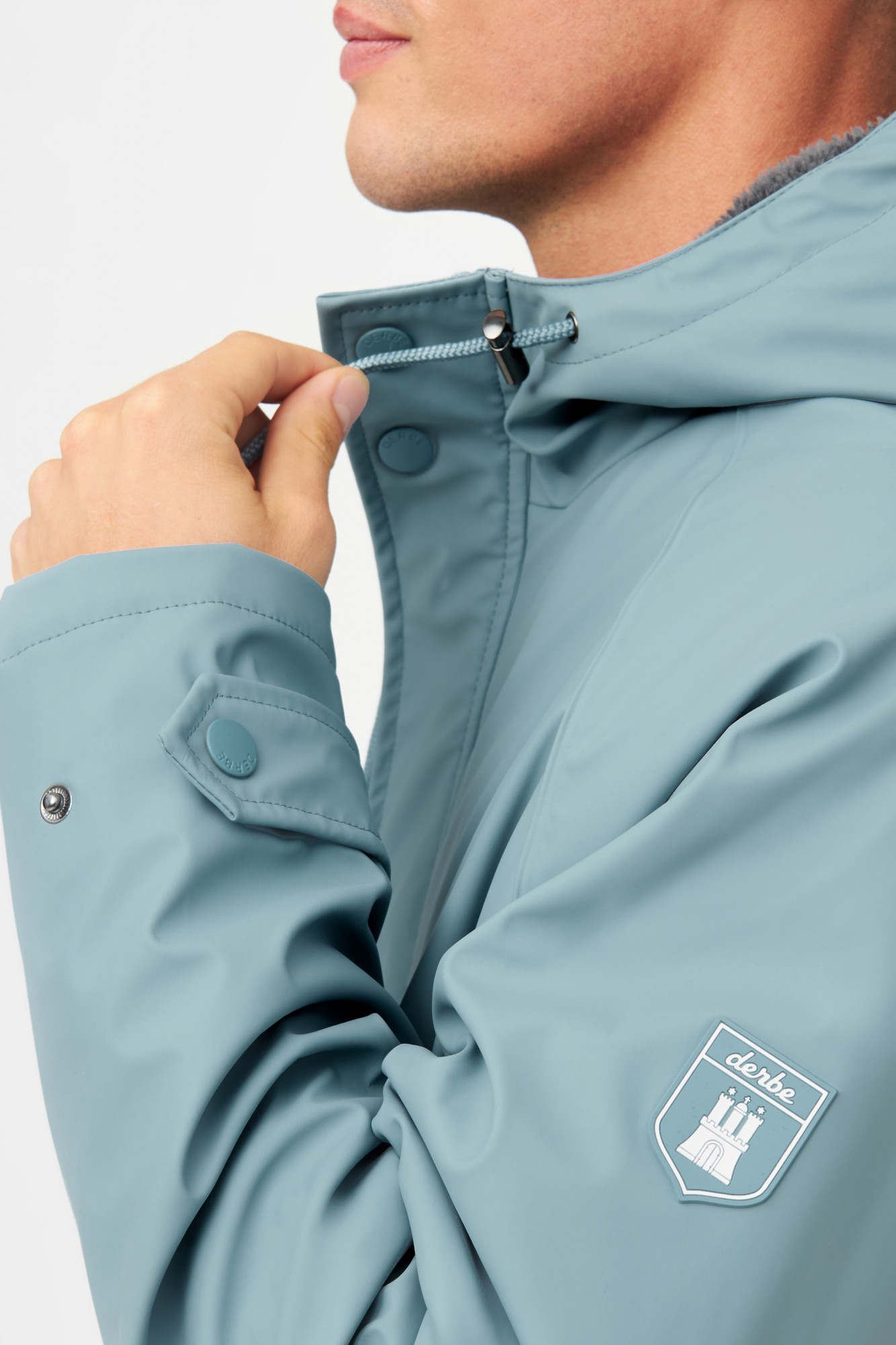 Model trägt eine Regenjacke blau von derbe