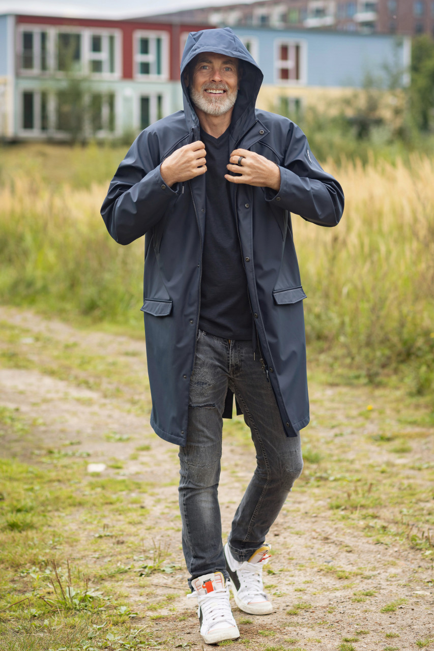 Mann trägt einen Regenparker blau von derbe  Outdoor Mood-Bild