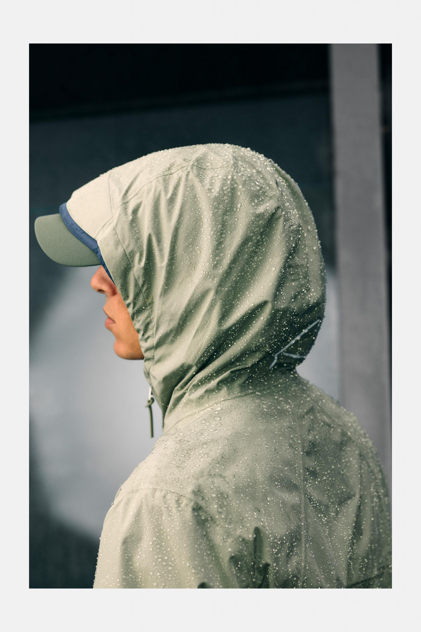 Mann trägt grüne Regenjacke - Seitlich - 6