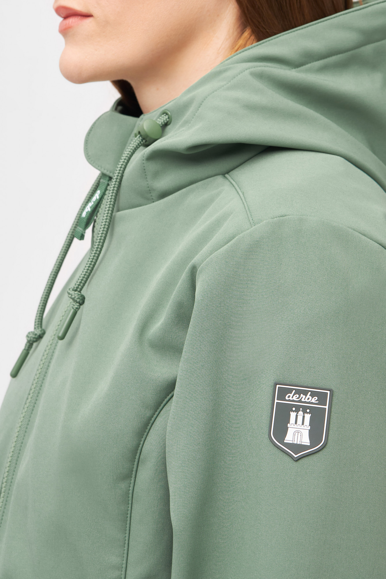 Model trägt eine Softshelljacke grün von derbe - Seitenansicht