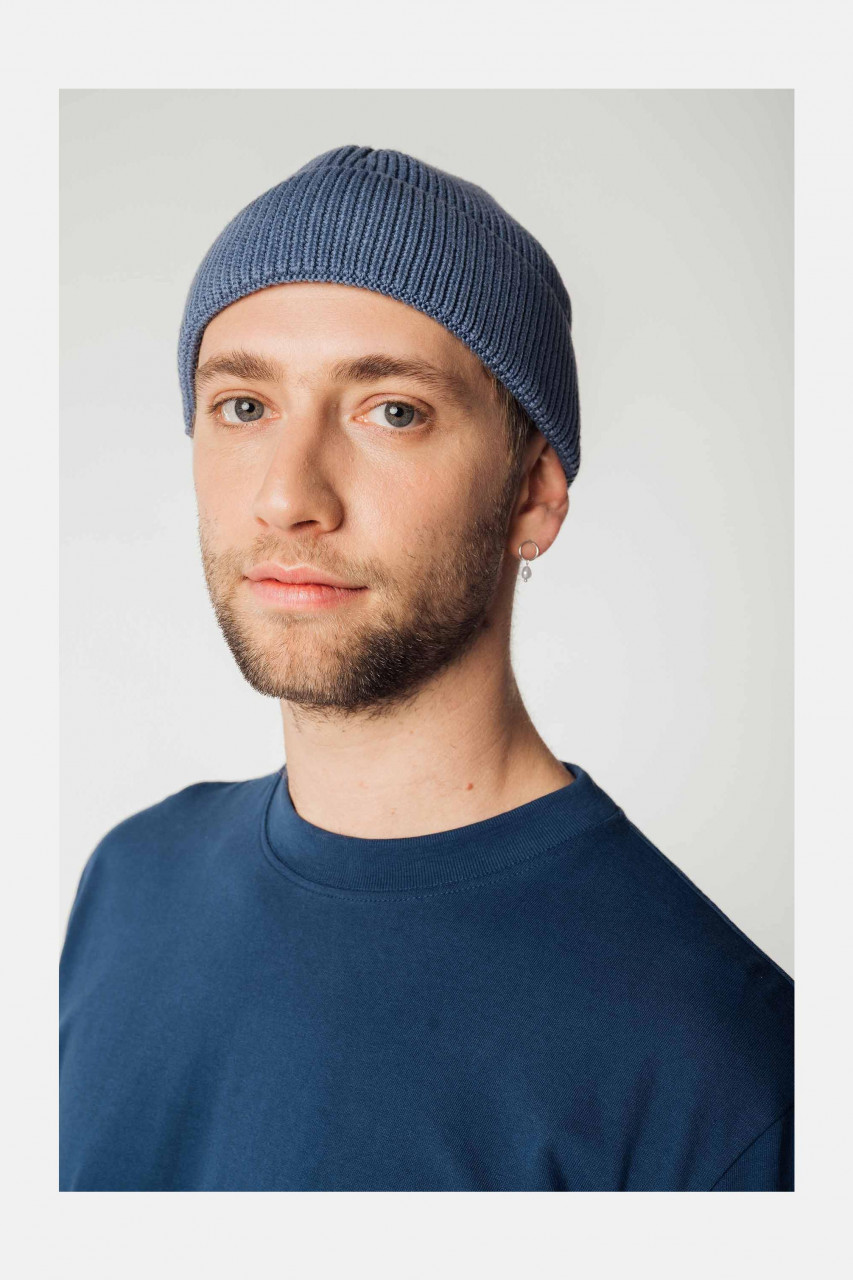 Model trägt eine blauen Strickmütze Unisex von MELA