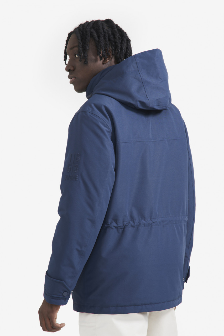 Mann trägt eine blaue Parka Unisex von Aigle - Seitlich