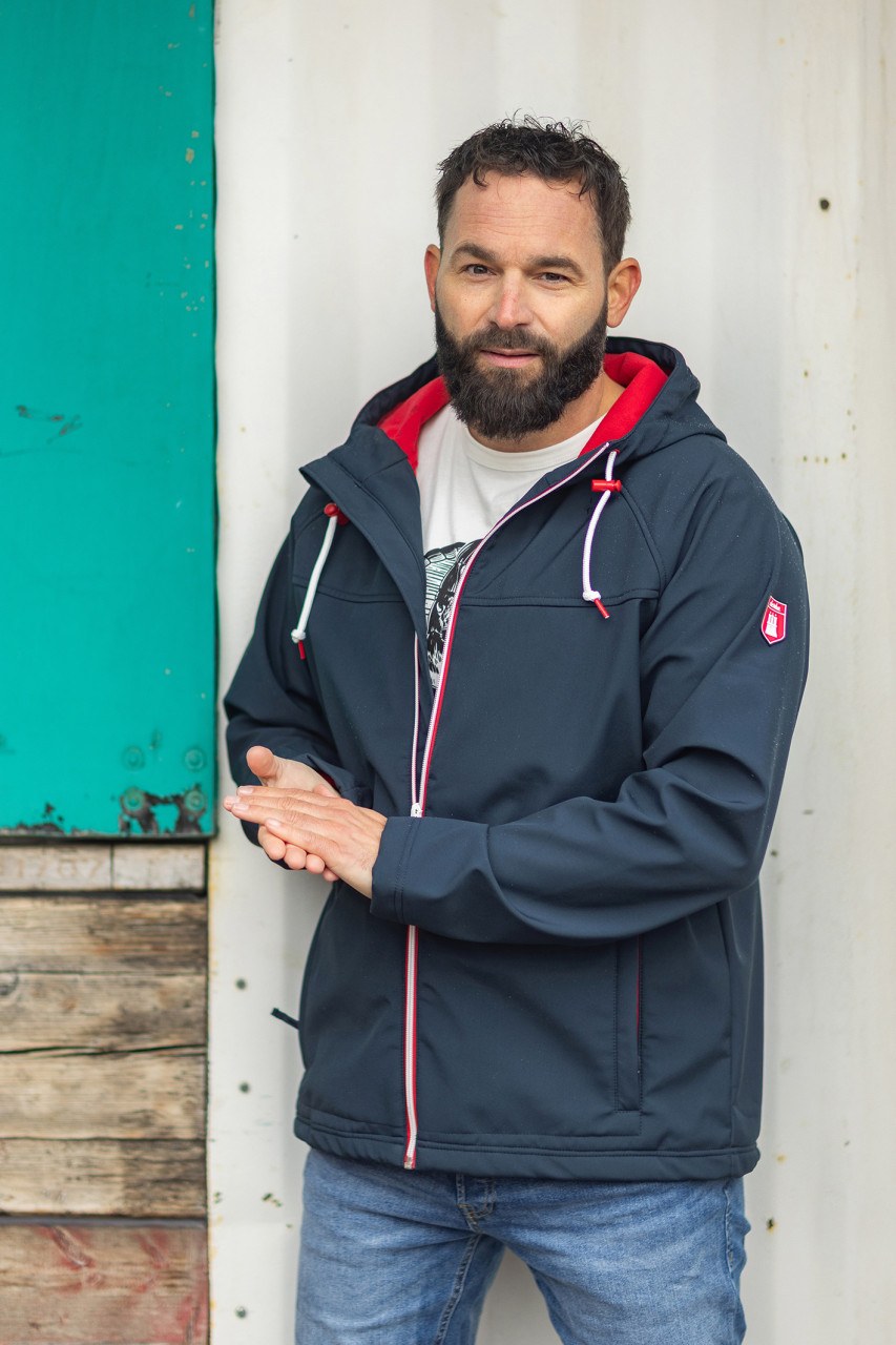 Mann trägt eine Softshell Jacke blau von derbe  Outdoor Mood-Bild